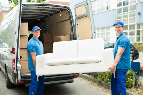 Removal staff wearing PPE while handling boxes and furniture