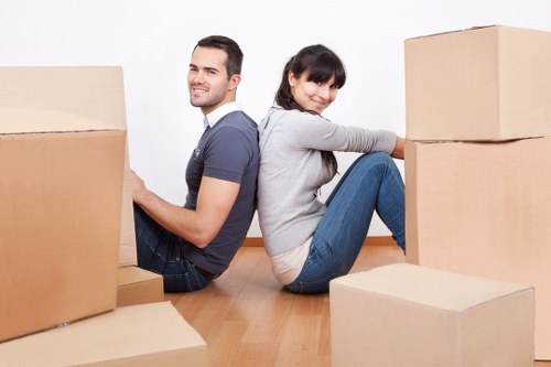 Movers carrying furniture through a flat entrance in Paddington